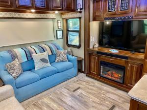 salon z niebieską kanapą i telewizorem w obiekcie Happy Hedgehog River Views Hot Tub Private w mieście Ahwahnee
