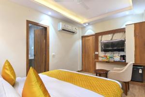 Habitación de hotel con cama y TV en The Saina International - New Delhi - Paharganj en Nueva Delhi