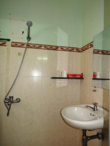 ein Bad mit einer Dusche und einem Waschbecken in der Unterkunft Kathy Hotel in Phan Thiet