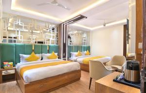 a hotel room with two beds and a desk at The Saina International Delhi - By La Exito Hotels in New Delhi