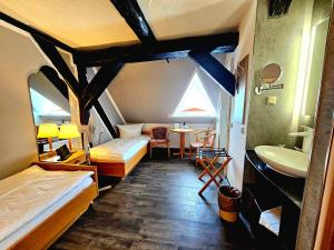 a room with two beds and a sink and a bathroom at Hotel Am Markt & Brauhaus Stadtkrug in Ueckermünde