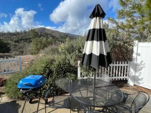 a table with an umbrella and a blue bag on it at The Funky Chicken Hot Tub BBQ SLEEPS 4 in Ahwahnee