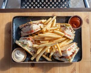 a tray with a sandwich and french fries on a table at Akti Dimis Hotel in Tigaki