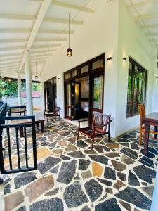 pokój z krzesłami i stołami na kamiennej podłodze w obiekcie White Villa Goyambokka w Tangalli