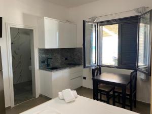 a kitchen with white cabinets and a table and chairs at Karaburun Sunset Beach in Orikum
