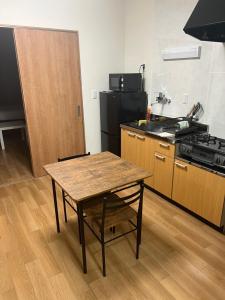 - une cuisine avec une table en bois et une cuisinière dans l'établissement Roxy inn, à Ōita