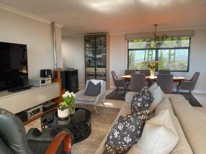 sala de estar con sofá y mesa en Constantia View Apartments OPERATIONAL DURING LOADSHEDDING en Ciudad del Cabo