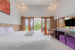 ein Schlafzimmer mit einem großen Bett und einem Flachbildfernseher in der Unterkunft Mandhasativa Homestay in Singaraja + 223 Fotos