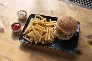 a plate with a hamburger and french fries on a table at Akti Dimis Hotel in Tigaki