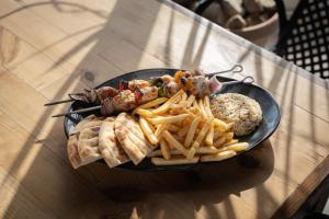 a plate of food with french fries and other foods at Akti Dimis Hotel in Tigaki