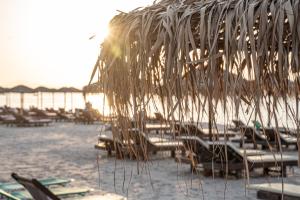 een groep stoelen en parasols op een strand bij Akti Dimis Hotel in Tigaki