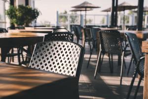 a row of chairs and tables in an outdoor restaurant at Akti Dimis Hotel in Tigaki