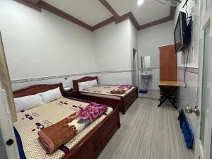 Habitación con 2 camas y TV. en Motel Khánh Vy, en Bao Loc