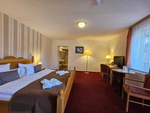 a hotel room with a bed with towels on it at Hotel Am Markt & Brauhaus Stadtkrug in Ueckermünde