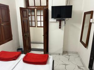 Cette chambre comprend 2 lits et une télévision à écran plat. dans l'établissement Hotel Laxminarayan Niwas, à Pune