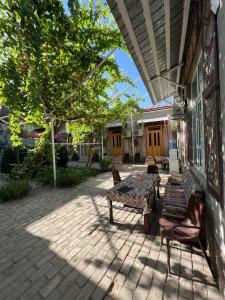 une terrasse avec une table et des chaises dans une maison dans l'établissement AL-MOTRUDIY, à Samarcande