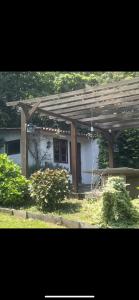 una pérgola de madera frente a una casa en Finca Las Bimbas, en Oleiros