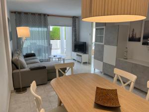 sala de estar con mesa y sofá en Amplio Apartamento con acceso directo a piscina en Platja  d'Aro