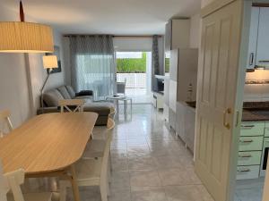 阿羅堡的住宿－Amplio Apartamento con acceso directo a piscina，厨房以及带桌子和沙发的客厅。