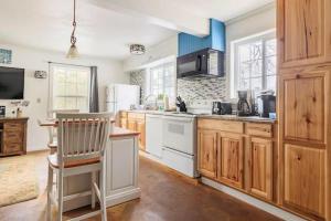 a kitchen with white appliances and a chair in it at Raccoon Hideout Hot Tub BBQ Arcade Darts in Oakhurst