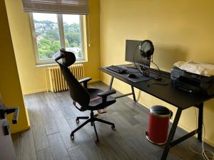 un bureau avec un bureau, un ordinateur et une chaise dans l'établissement Clam，grand apartment in Uccle, à Bruxelles