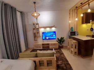 ein Wohnzimmer mit einem TV, einem Sofa und einem Tisch in der Unterkunft EnN 2 Lovely Premium Apartment in Bungoma