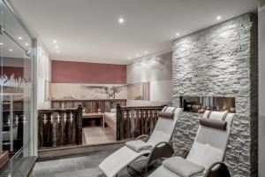 a salon with chairs and a stone wall at Hotel Elisabeth Superior Sölden in Sölden