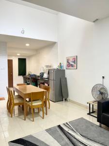 a kitchen and dining room with a table and a refrigerator at MOFA Homestay Near KLIA Airport in Sepang