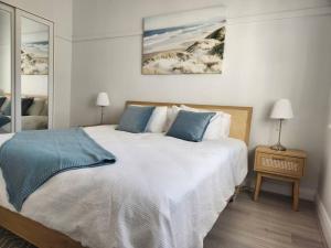 a bedroom with a large white bed with blue pillows at WOW - King Beds, Huge Yard, New Reno, close to Beach, Private, Level no stairs in Sydney