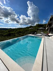 a swimming pool with blue water on a building at V Residence Apartments in Rabac