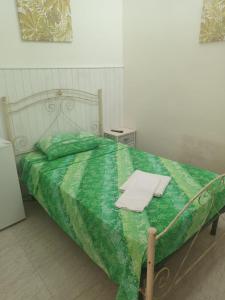 um quarto com uma cama com um edredão verde em Affittacamere CALAMOSCHE em Noto