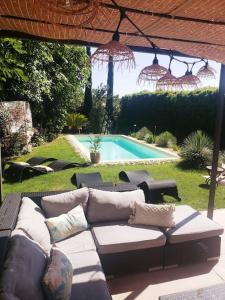 a patio with a couch and a swimming pool at La villa Pausa en Drôme provençale in Montboucher-sur-Jabron