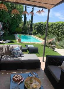a patio with a couch and a swimming pool at La villa Pausa en Drôme provençale in Montboucher-sur-Jabron