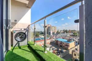 balcón con vistas a la ciudad y lavadora en Lovely furnished cozy 2Bed/Room, en Nairobi