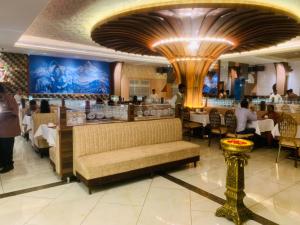 a dining room with a bench in a restaurant at Rajathadri Royal Inn in Bangalore