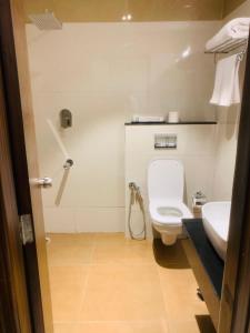 a bathroom with a toilet and a sink at Rajathadri Royal Inn in Bangalore +23 photos