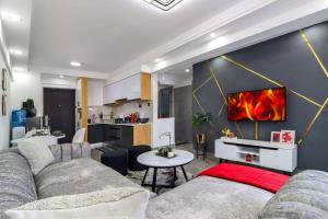 sala de estar con sofá y cocina en Lovely furnished cozy 2Bed/Room, en Nairobi
