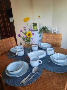 uma mesa com pratos e colheres azuis e brancos em Sėlių 25 Šeimos Būstas em Šiauliai