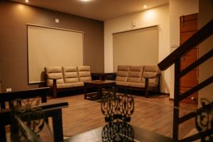 a waiting room with two chairs and a large screen at Mellow Mount Private Homestay in Ooty
