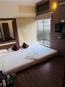 ein großes Bett in einem Zimmer mit einem großen Fenster in der Unterkunft Mellow Mount Private Homestay in Udagamandalam