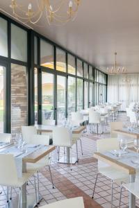 a dining room with white tables and white chairs at Le Terrazze sul Lago Hotel & Residence in Padenghe sul Garda