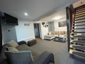 密古雷休治Morrison Apartments的带沙发、椅子和电视的客厅