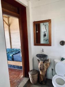 uma casa de banho com um lavatório, um WC e uma cama em Dikaloha Surfschool and Stay em Airsatang