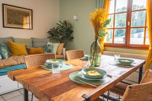una mesa de madera con platos de comida en la sala de estar en GîTE DES CROIX, en Bergnicourt