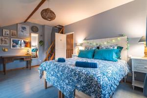- une chambre avec un grand lit et des oreillers bleus dans l'établissement GîTE DES CROIX, 