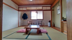 een woonkamer met een houten tafel en stoelen bij Matsunoki-tei in Otari