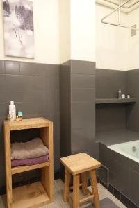 een badkamer met een wastafel, een tafel en een kruk bij La villa des Tacounets 20 pers in Saint-Gervais-les-Bains
