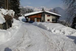 a snow covered road in front of a house at La villa des Tacounets 20 pers in Saint-Gervais-les-Bains