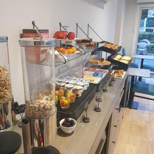 una linea a buffet con molti tipi di cibo diversi di Logis Hotel La Closerie a La Baule