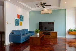 a living room with a blue couch and a tv at ALEAH HOME in Hanoi